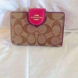 Used once. Like new Coach wallet with hot pink trim.
